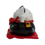 Black ceramic money cat bank on red cushion, front view